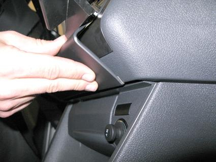 En hand installerar en del på instrumentpanelen i en Volkswagen Caddy.