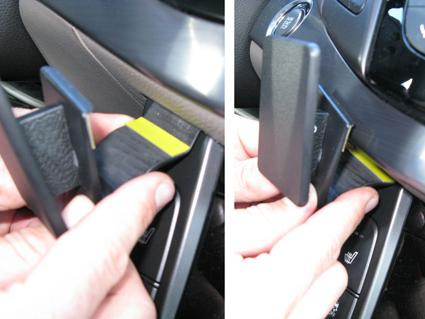 En hand som placerar en del i en bils instrumentpanel.