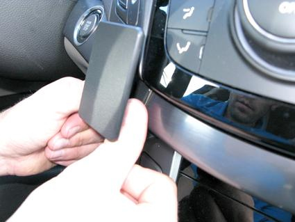 En hand monterar en del på instrumentpanelen i en Hyundai i40.