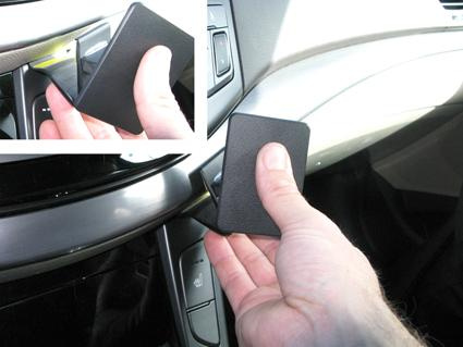 En hand håller ett svart kort i en bils interiör.