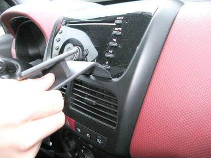 Bild visar en hand som justerar kontroller på Fiat Doblo 10-14:s instrumentpanel.