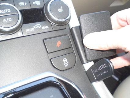 Kontrollpanel med knappar och vred i en Land Rover bil.