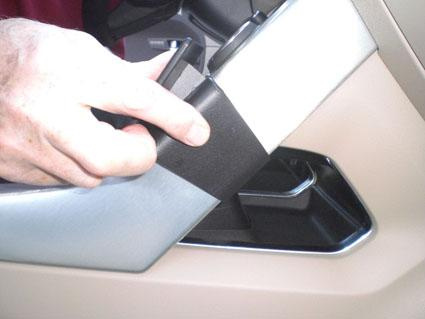 En hand justerar en del av inredningen på en Landrover Range Rover Evoque.