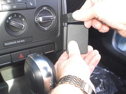 En person installerar en enhet i en Volkswagen Beetle.