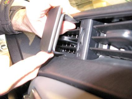 En person installerar en del i ventilationssystemet i en Toyota Yaris.