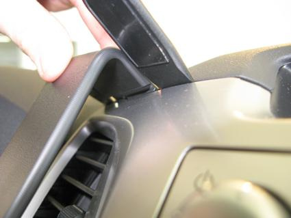 Visar en hand som öppnar en panel i en Toyota HiLux.