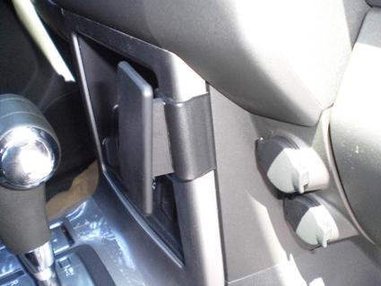 Del av interiören i en Nissan Pathfinder 10-12 med kontroller och fack.