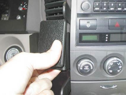 En hand håller i ett del av instrumentpanelen i Kia Sorento 02-07.