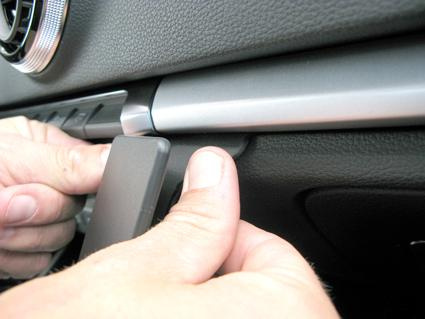 Hand som tar bort en panel i en Audi A3 13-15.