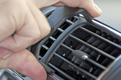 En hand justerar luftventilen i en Dodge Journey.