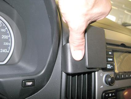 En hand som trycker på en del av en bilinteriör.