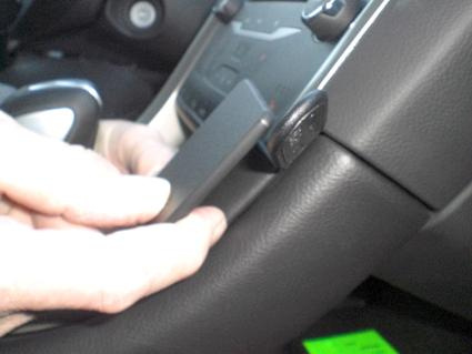 En hand håller en enhet mot bilens kontrollpanel i en Ford Mondeo.