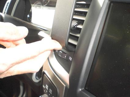 En hand trycker på en knapp i en Dodge Ram Pick Up.