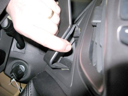 En hand visar en del i Ford Transit 14-15 inuti bilen.