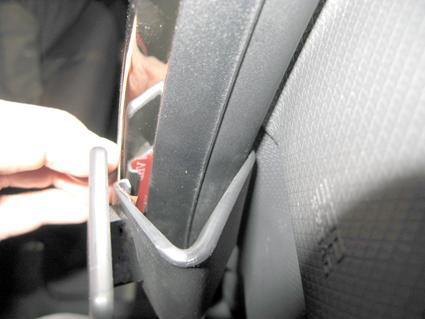 En hand som placerar något i en hållare i bilen, Renault Clio 13-15.