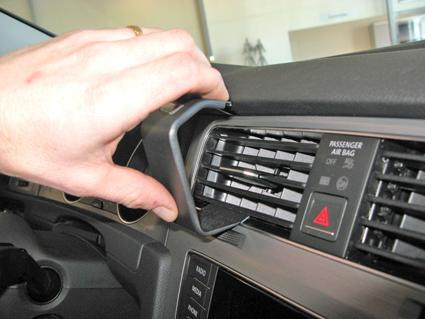 En hand justerar ett luftrör i en Volkswagen Golf VII.