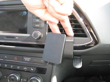 En hand håller en vinklad enhet som fästs på instrumentpanelen.