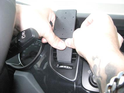 En person fäster en hållare på bilens luftventil.