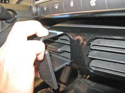 En hand öppnar en luftventil i ett bilintérieur.