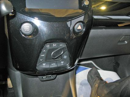 Instrumentpanel med knappar för luftkonditionering och start/stopp i Toyota Aygo.