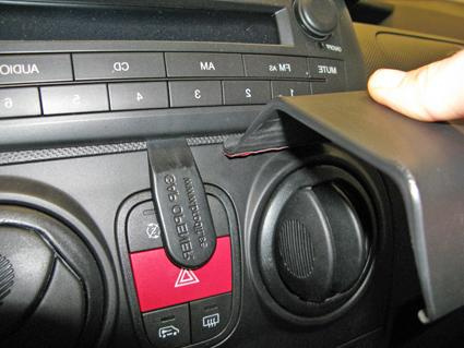 En hand som justerar en del av bilens instrumentbräda.