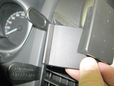 En svarts plastfäste för mobilhållare i en bil.