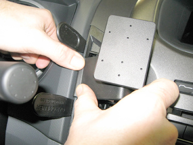 Hand som installerar en komponent på en Ford Ranger 12-15.