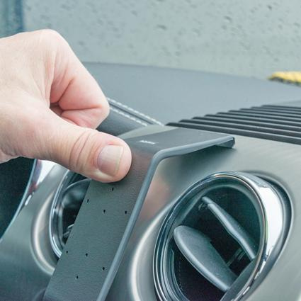 En hand som håller en monteringsbygel för Ford Mustang.