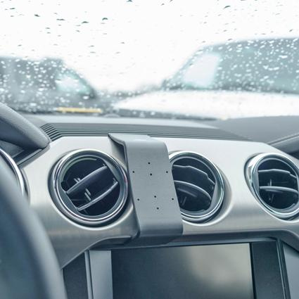 Monteringsbygel fästad vid bilens luftventiler.