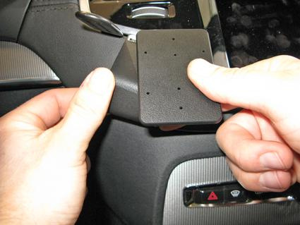 En person håller i en svart fästplatta för Volvo XC90.