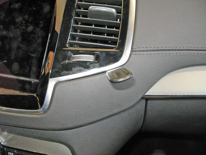 Detalj av bilinteriör med läder och metallfinish.