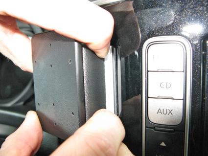 Hand som fäster en monteringsbygel på en bilinteriör.