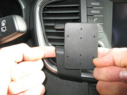 En hand håller en monteringsplatta för Kia Sorento i bilen.