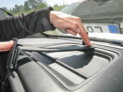 En hand justerar en hållare på instrumentpanelen i en bil.