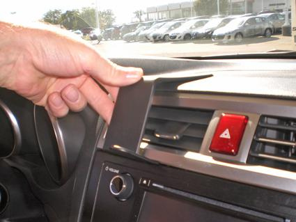 Hand som justerar en panel i en bilinteriör.