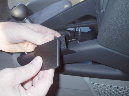 En person håller i en svart monteringsbygel för Audi A3.