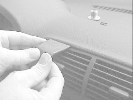 En hand fäster en monteringsbygel på instrumentbrädan av en Audi A3.