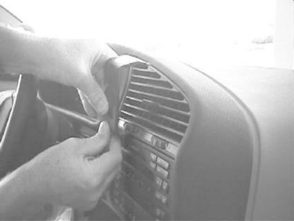 En hand installerar en ProClip monteringsbygel på en BMW:s instrumentbräda.