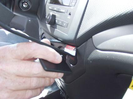 En hand placerar en enhet på en bils instrumentbräda.