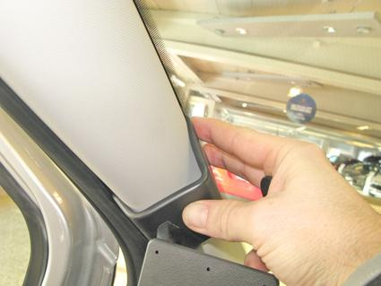 En hand som håller i en monteringsbygel för Ford Transit Connect.