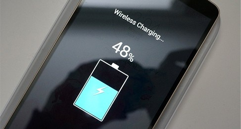 En smartphone visar 48% batterinivå under trådlös laddning.