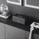 Audio Pro Drumfire D-2 Wifi-högtalare med Google Cast & AirPlay 2, svart En svart högtalare på ett sideboard med dekorationer och en gitarr i närheten.