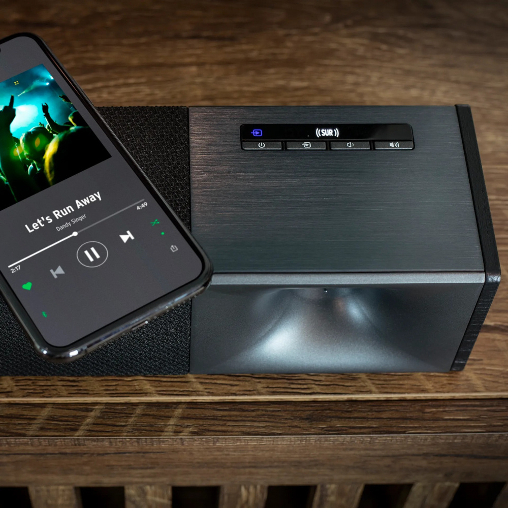 En soundbar med trådlös subwoofer och musikspelande smartphone.