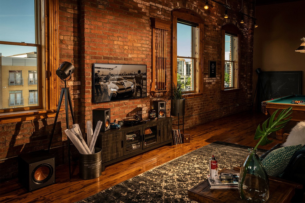 Ett rum med tegelväggar, trägolv och ljudanläggning inklusive en subwoofer.