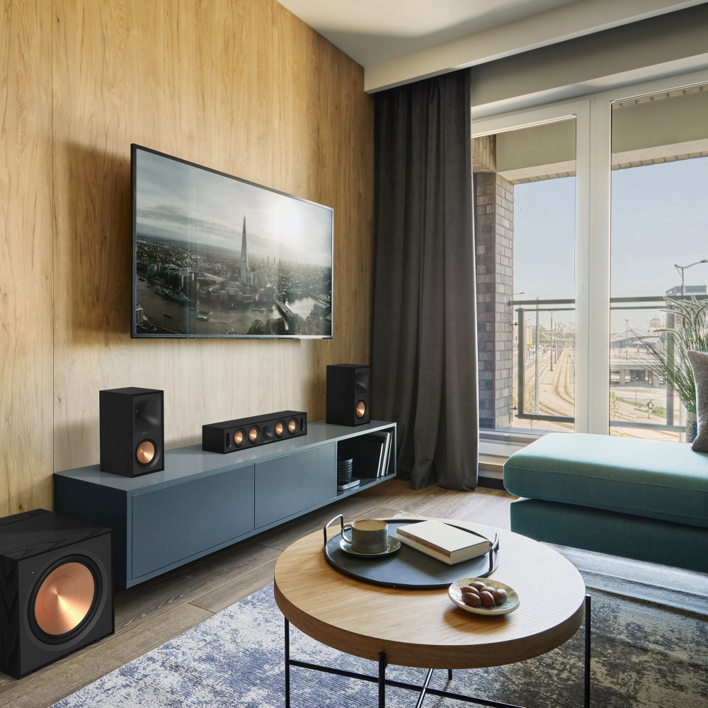 En modern loungemiljö med TV och Klipsch-högtalare i svart.