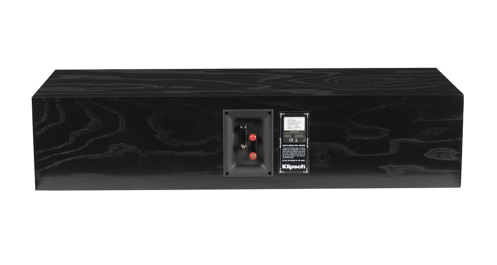 En svart centerhögtalare med äkta träfanér och anslutningsuttag bakom.