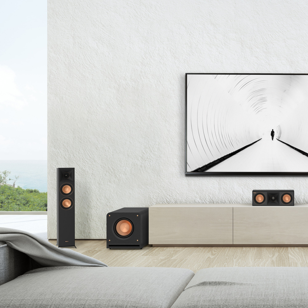 En modern vardagsrumsinställning med en TV, ljudsystem och en svart subwoofer.