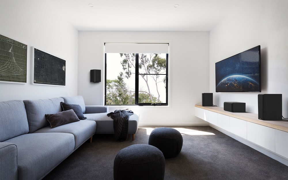 En modern vardagsrumsmiljö med en svart centerhögtalare och TV.