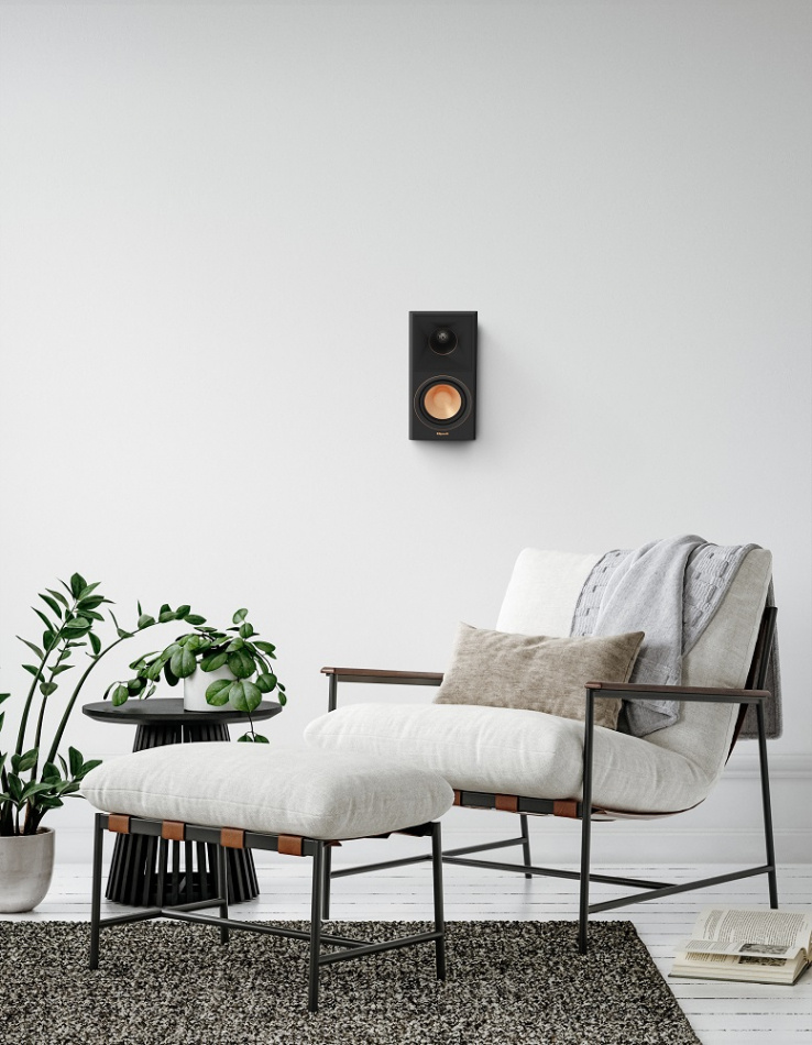 En modern sittgrupp med en väggmonterad högtalare och växt.