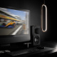 Klipsch The Fives McLaren Edition aktiva högtalare med HDMI, svart Aktiva högtalare i svart med elegant design, placeras vid en dator med racingbild.